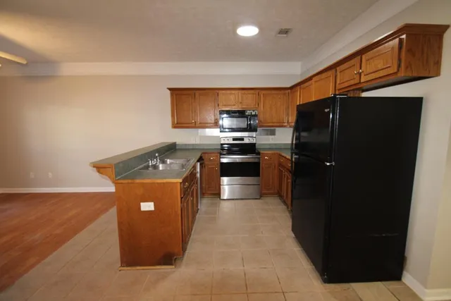 a kitchen with stainless steel appliances granite countertop a stove a refrigerator a sink and dishwasher