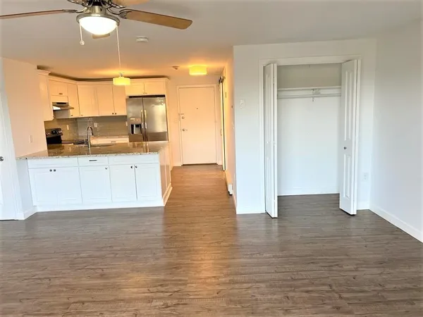 a large kitchen with cabinets wooden floor and a sink