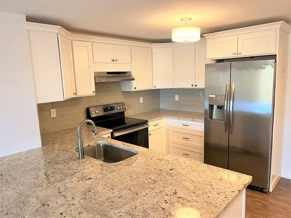 a kitchen with a refrigerator sink and cabinets
