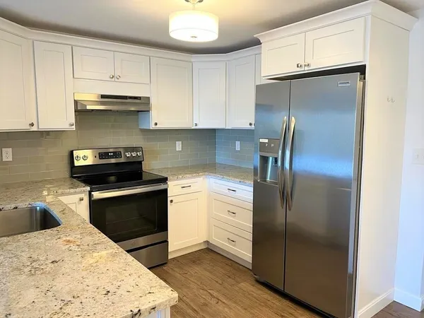 a kitchen with a refrigerator and a stove