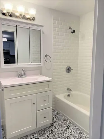 a bathroom with a bathtub a sink a vanity and a window