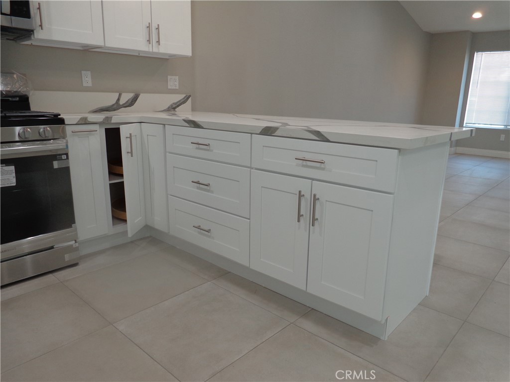 12744 Running Deer Road Apple Valley, CA 92308 - Photo 11 of 30 a kitchen with white cabinets and white appliances