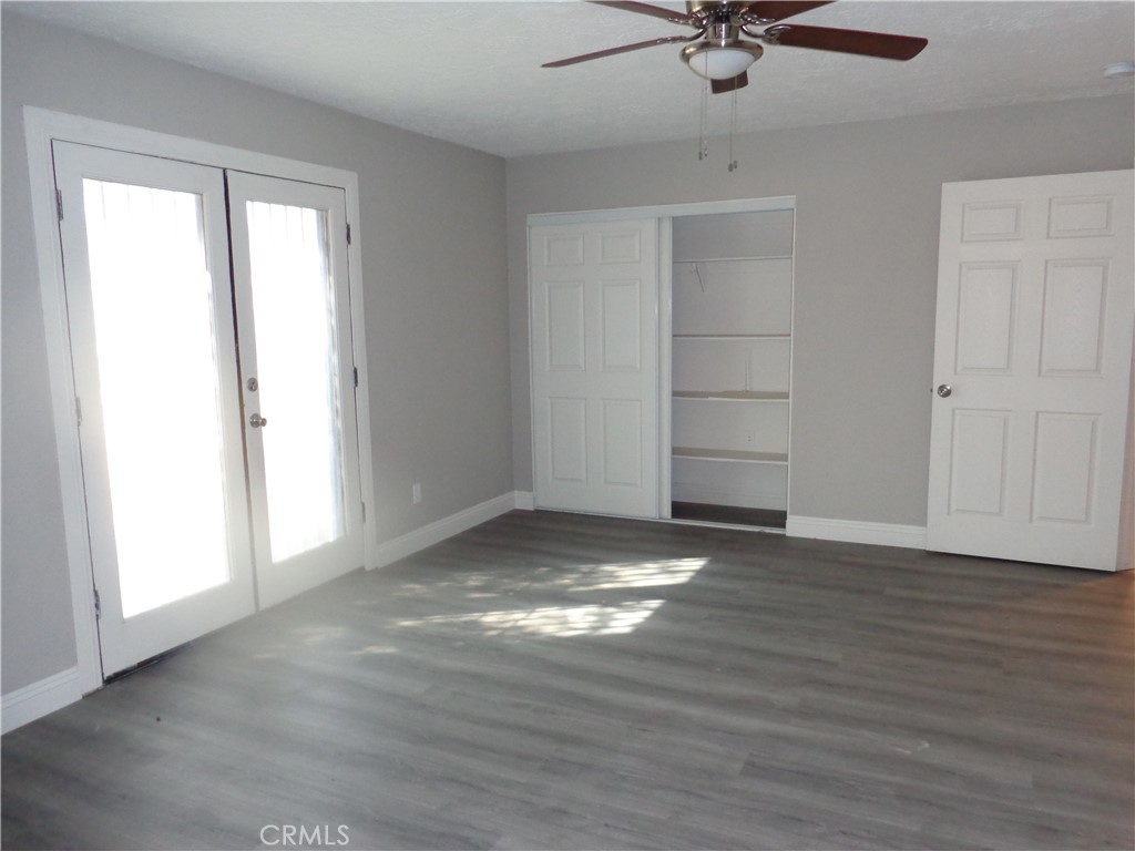 12744 Running Deer Road Apple Valley, CA 92308 - Photo 14 of 30 a view of an empty room with a window and a ceiling fan