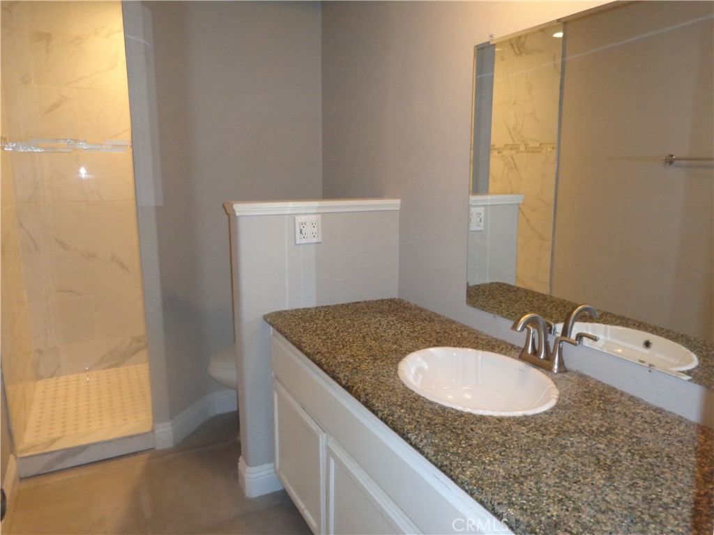12744 Running Deer Road Apple Valley, CA 92308 - Photo 16 of 30 a bathroom with a granite countertop sink and a mirror