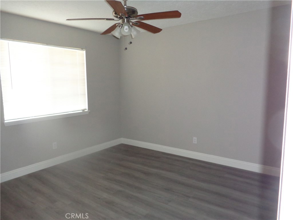 12744 Running Deer Road Apple Valley, CA 92308 - Photo 19 of 30 an empty room with wooden floor closet and windows