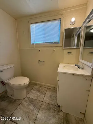 a bathroom with a sink a toilet and a mirror