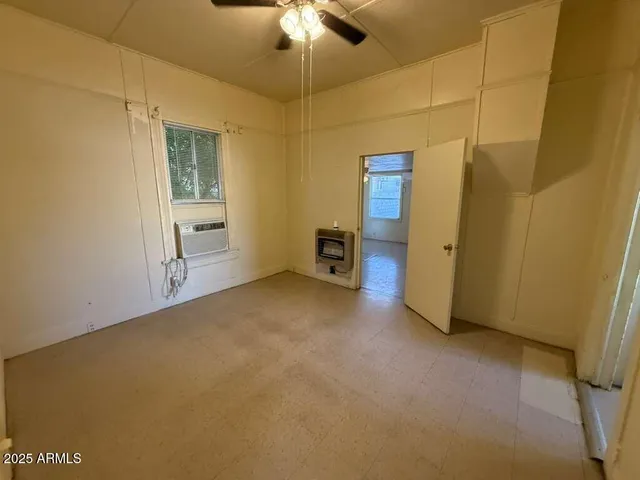 an empty room with a ceiling fan and a bathroom
