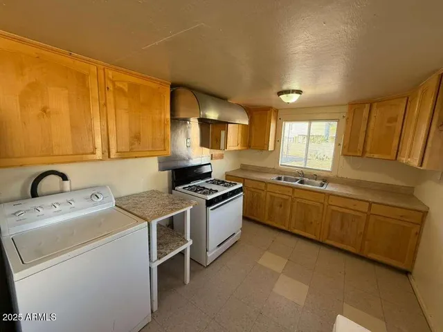 a kitchen with a stove sink and cabinets