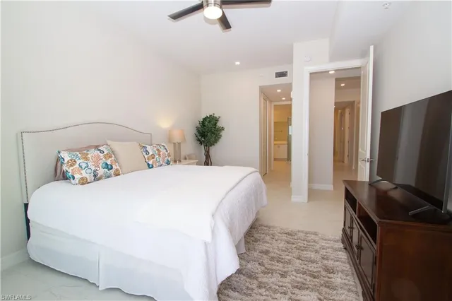 a spacious bedroom with a bed and flat screen tv