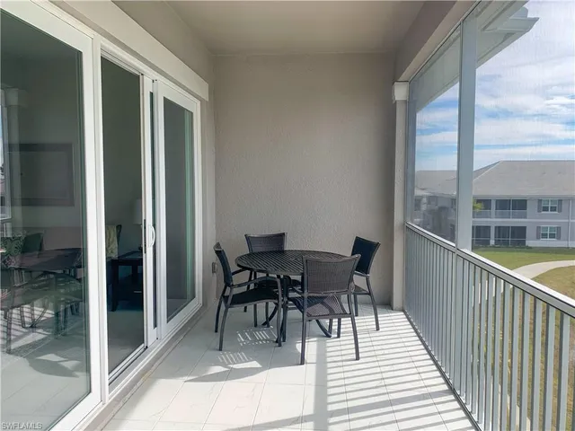 a balcony with chairs and glass door