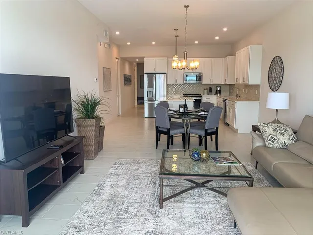 a living room with kitchen furniture and a flat screen tv