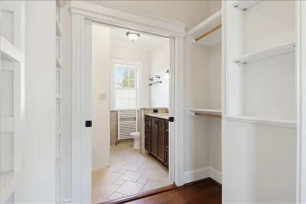 a front view of a house with garden and trees