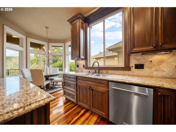 a kitchen with stainless steel appliances granite countertop sink stove and large window