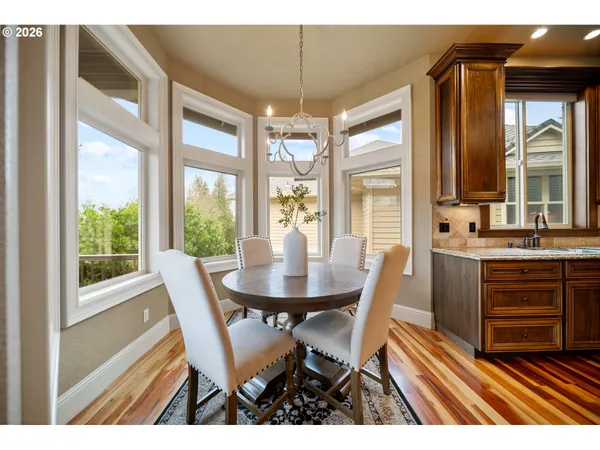 a dining room with furniture a chandelier and wooden floor