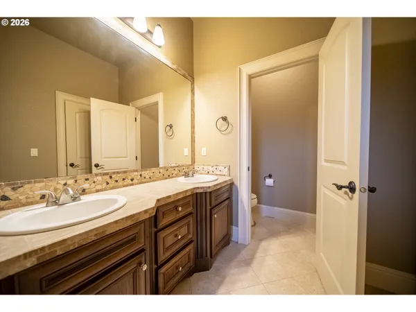 a spacious bathroom with a granite countertop sink a mirror and a