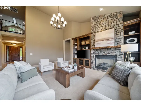 a living room with furniture a fireplace and a chandelier