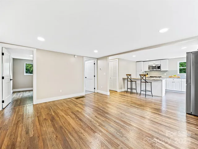 a view of an empty room with wooden floor