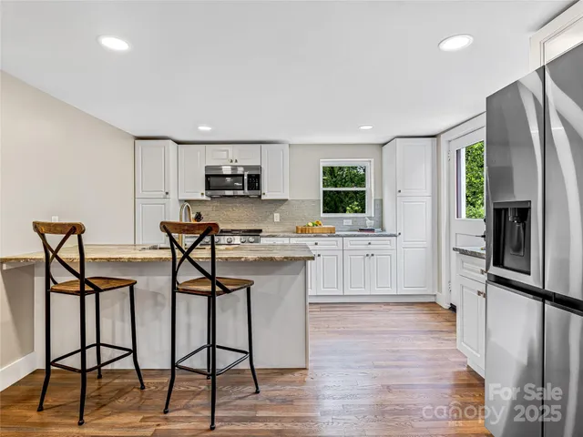 a kitchen with stainless steel appliances a refrigerator and a stove top oven
