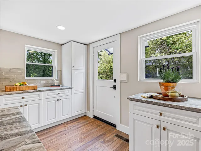 a kitchen with sink window and wooden floor