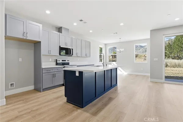 a large kitchen with stainless steel appliances granite countertop a large stove a sink dishwasher and a refrigerator with wooden floor