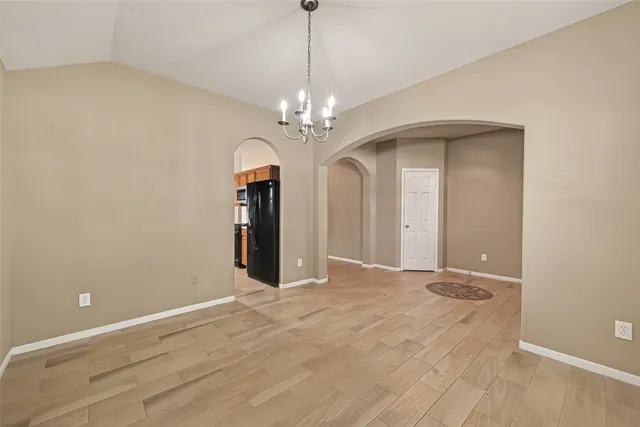 an empty room with windows and ceiling fan
