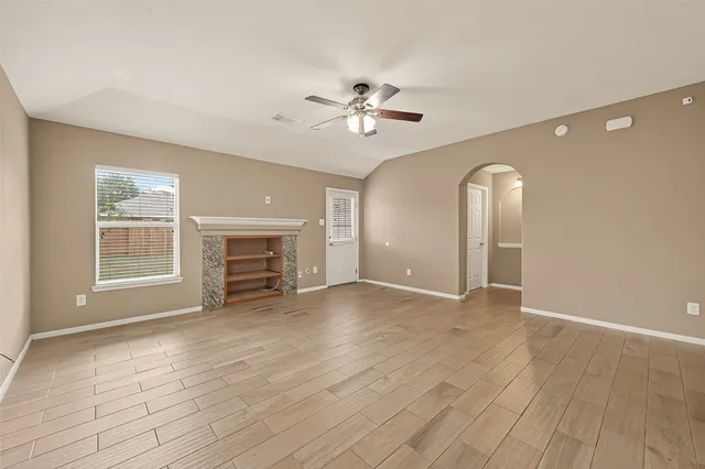 a view of empty room with wooden floor and fireplace