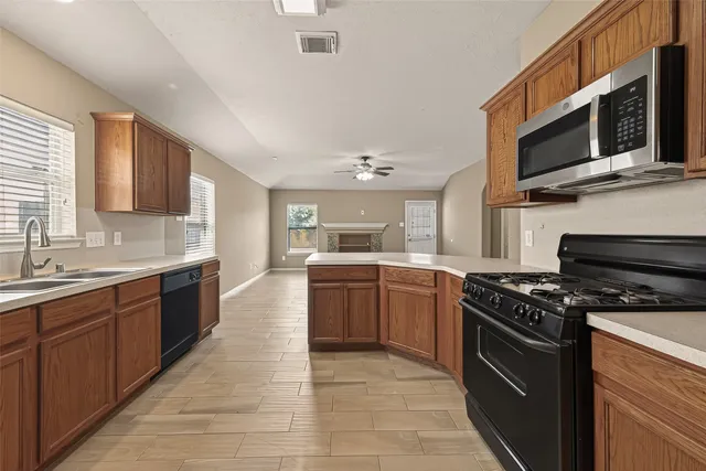 a kitchen with stainless steel appliances granite countertop a stove microwave and sink