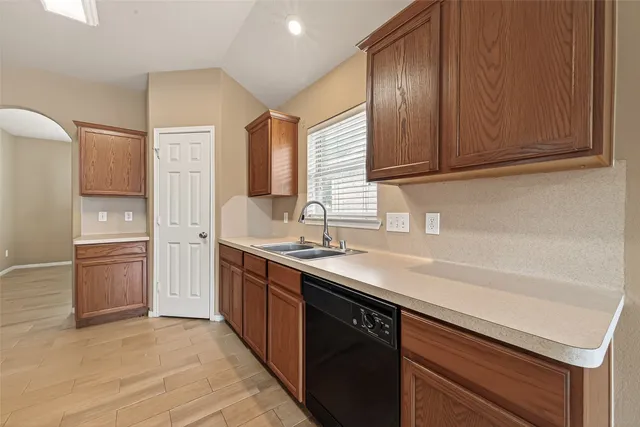 a kitchen with stainless steel appliances granite countertop a sink stove refrigerator and cabinets