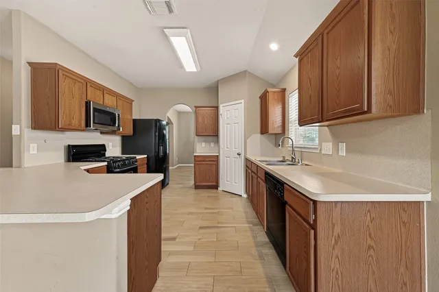 a large kitchen with stainless steel appliances a refrigerator and a stove top oven