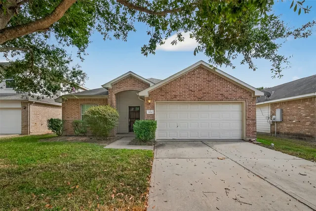 front view of a house with a yard and an trees