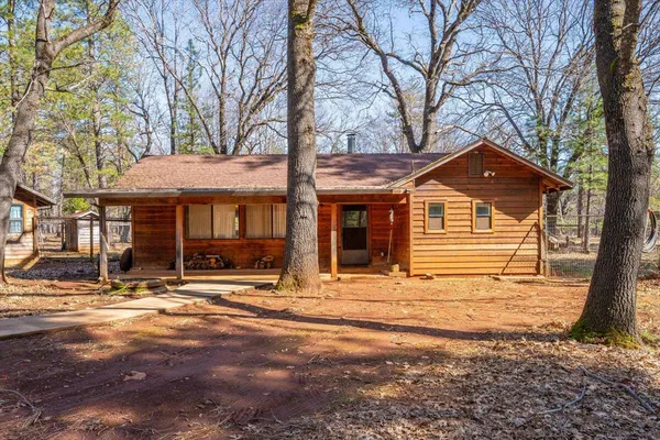 a front view of a house with yard and trees in the background