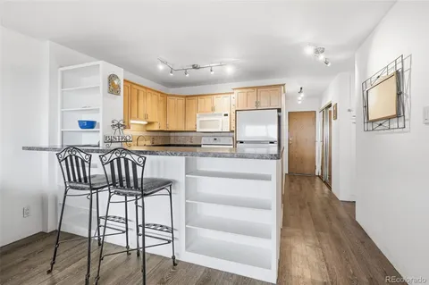 a kitchen with granite countertop a refrigerator stove microwave and cabinets