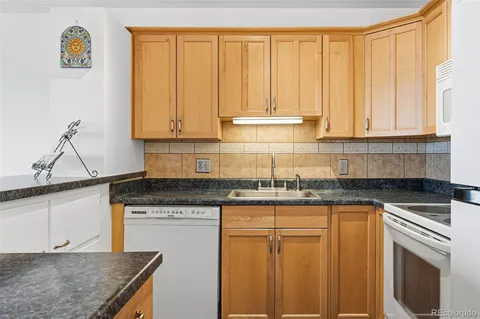 a kitchen with granite countertop stainless steel appliances a stove window and cabinets