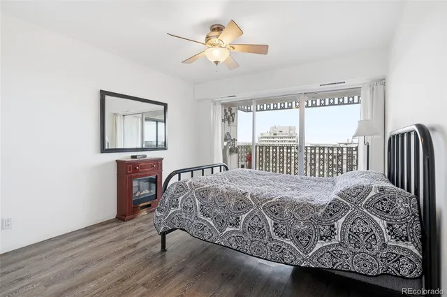 a bedroom with a bed painting on wall and a large window