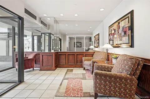 a living room with furniture large mirror and glass door