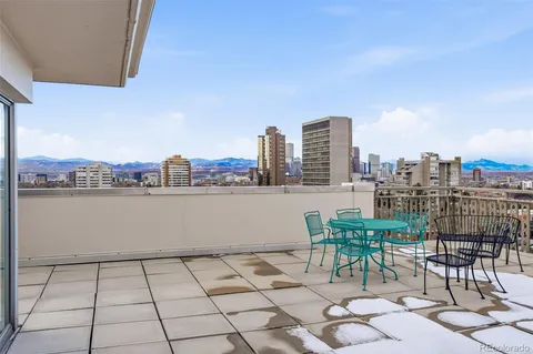 a view of a terrace with furniture and city view