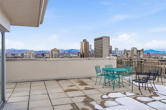 a view of a terrace with furniture and city view