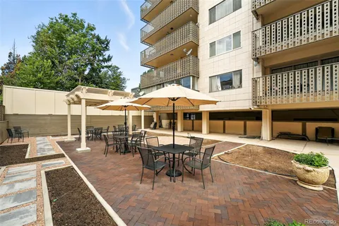 a view of a patio with a dining table and chairs with wooden floor