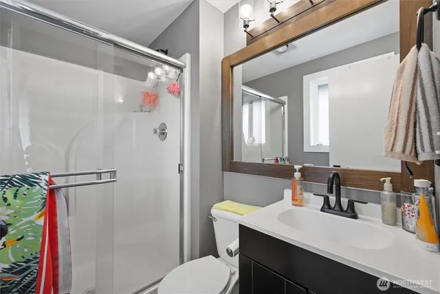 a bathroom with a sink vanity mirror and toilet