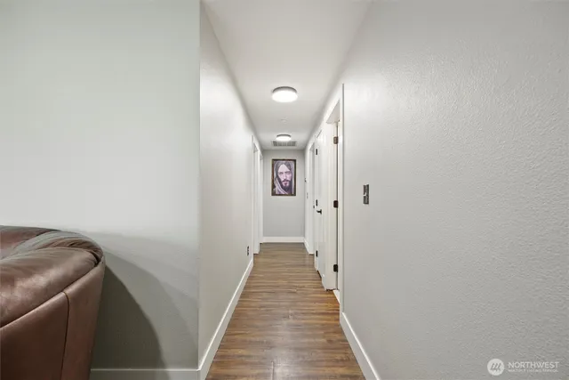 a view of a hallway with wooden floor