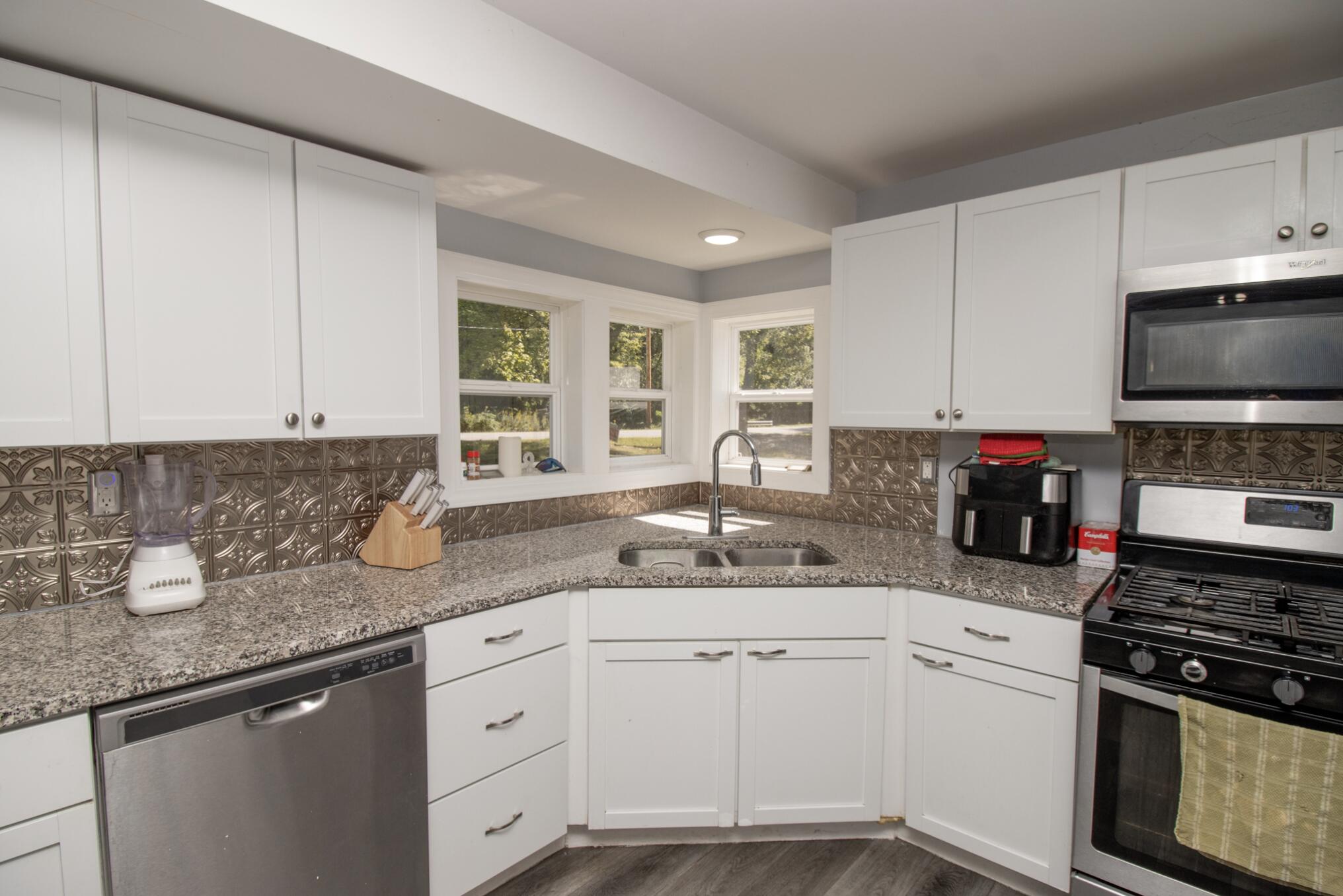 15806 Clark Street Lowell, IN 46356 - Photo 9 of 35 a kitchen with stainless steel appliances granite countertop a sink stove and cabinets
