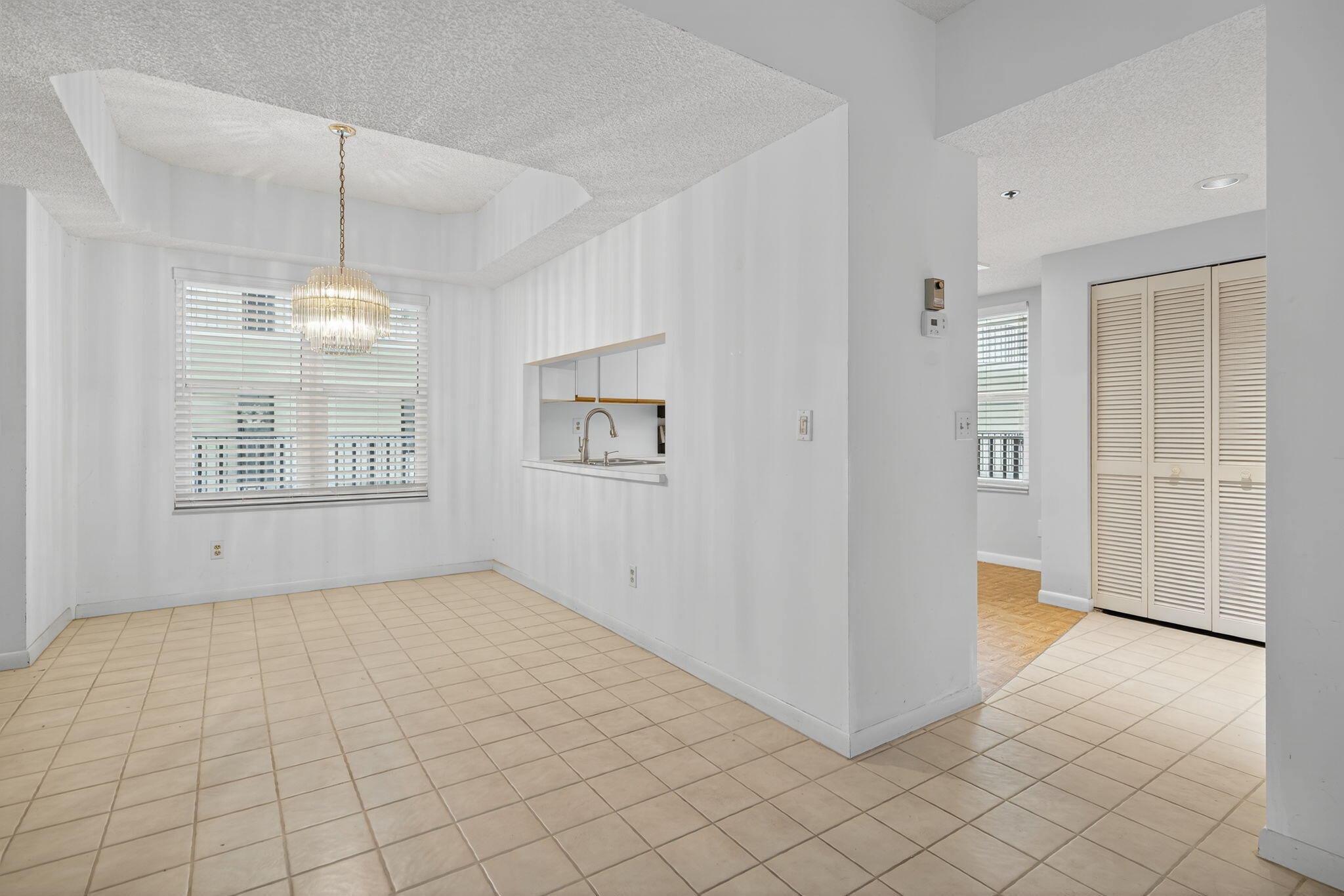 221 Northeast Plantation Road, Unit 213 Stuart, FL 34996 - Photo 11 of 44 an empty room with windows and chandelier