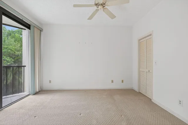 a view of empty room with sliding door and balcony