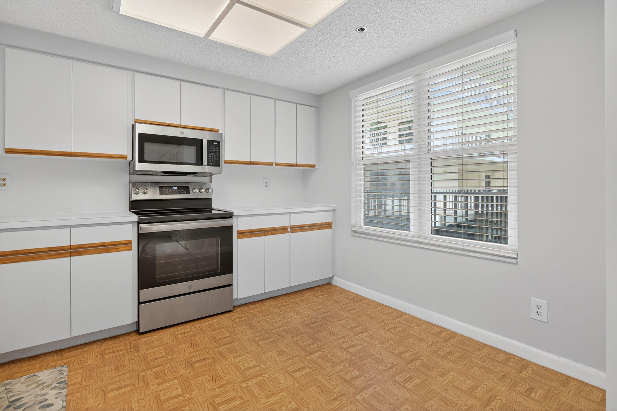 221 Northeast Plantation Road, Unit 213 Stuart, FL 34996 - Photo 34 of 44 a kitchen with granite countertop a stove a sink and a microwave