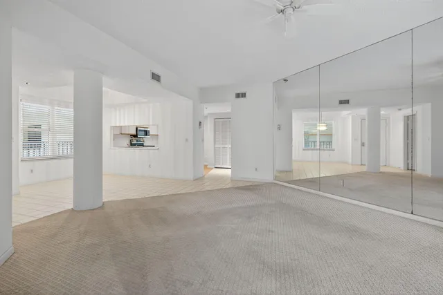 a view of a livingroom with wooden floor and a bathroom