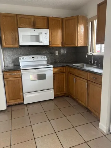 a kitchen with a stove sink and cabinets