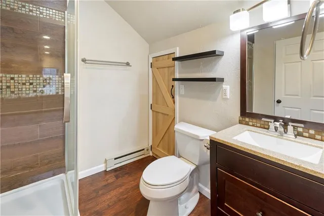 a bathroom with a sink a toilet and shower