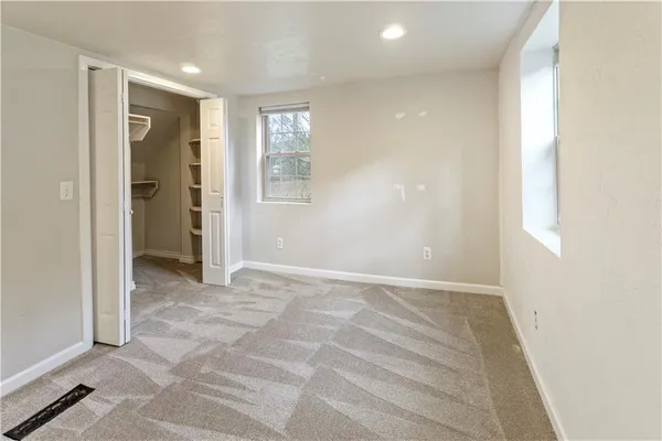 an empty room with windows and closet