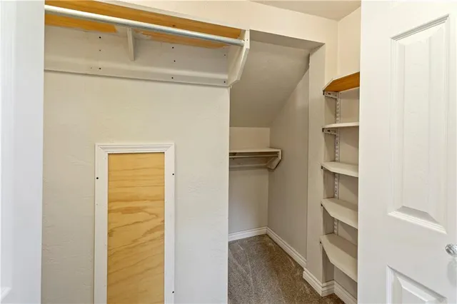 a view of walk in closet with empty racks