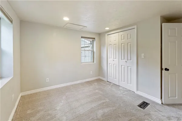 an empty room with windows and closet